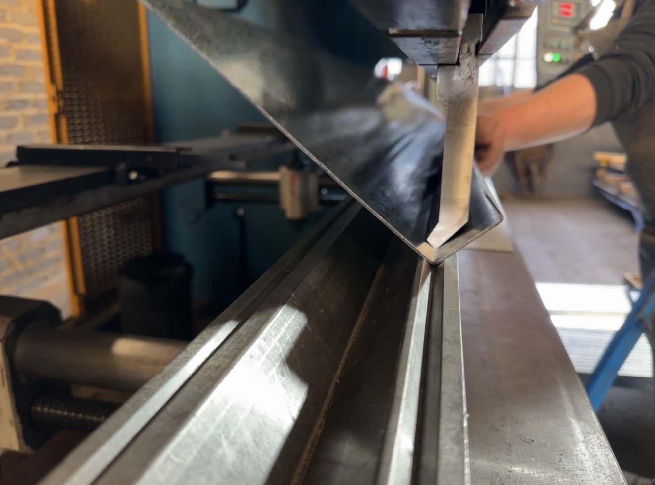 Press brake machine bending a piece of sheet metal