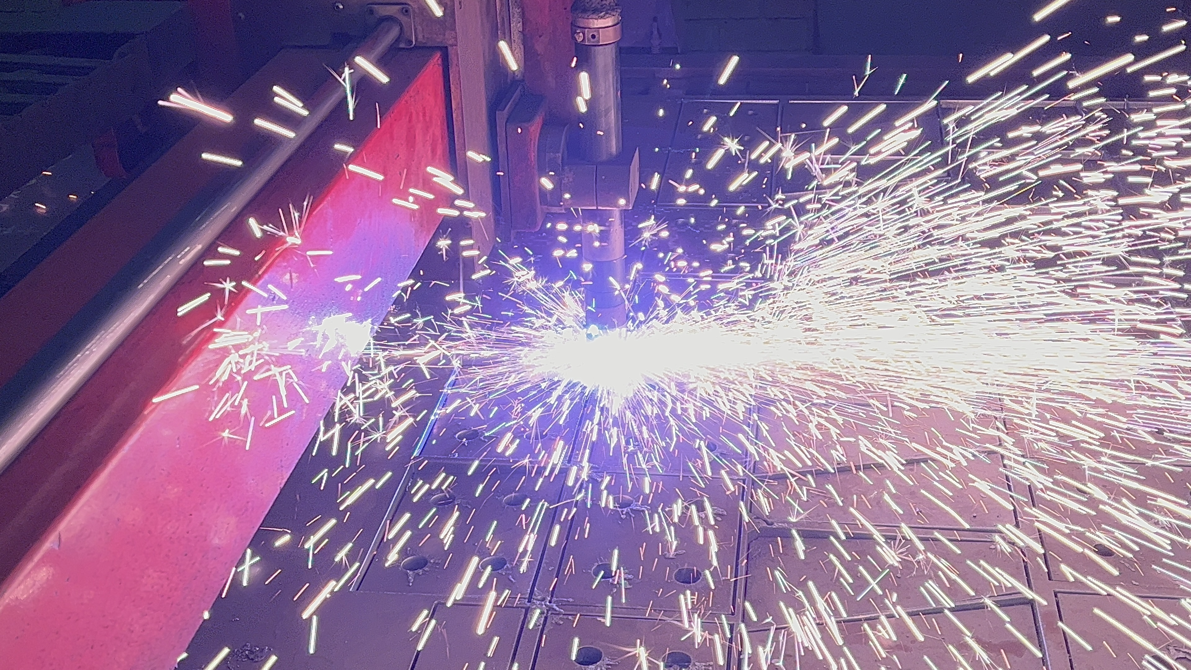 Plasma cutter slicing through thick steel with sparks
